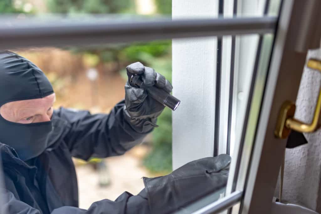 Einbrecher will mit einer Brechstange ein Fenster aufhebeln